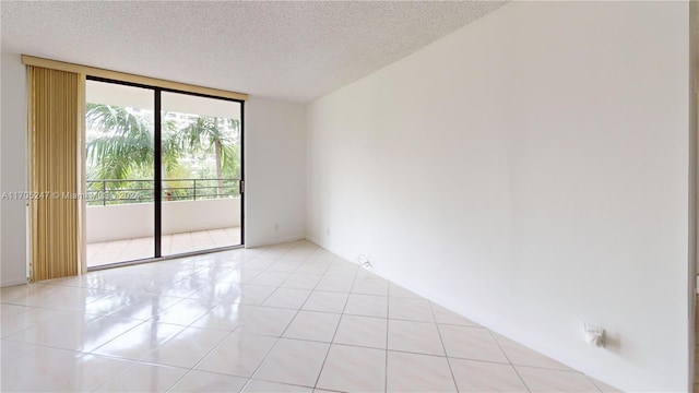 unfurnished room featuring a textured ceiling and floor to ceiling windows