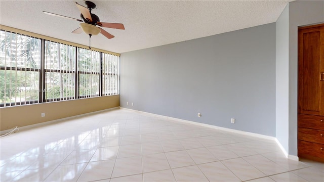 unfurnished room featuring ceiling fan, light tile patterned floors, and a textured ceiling