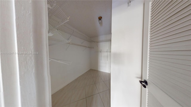 spacious closet with light tile patterned floors