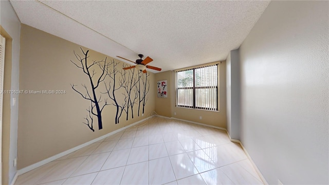 tiled empty room featuring a textured ceiling and ceiling fan