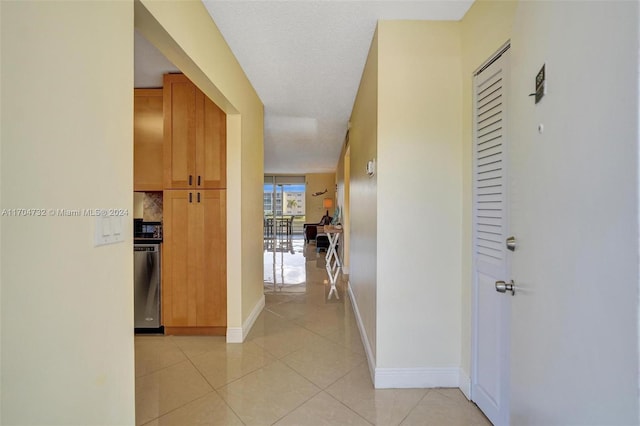 hallway featuring light tile patterned flooring and a textured ceiling