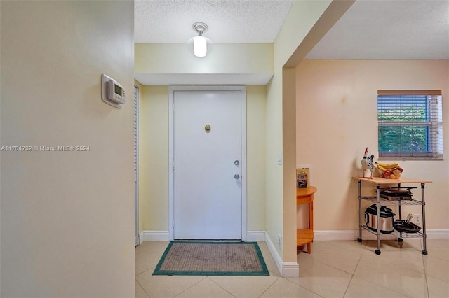 foyer featuring light tile patterned floors and a textured ceiling