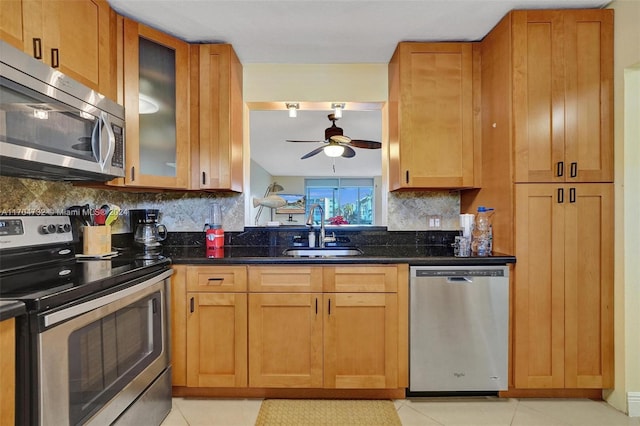 kitchen with tasteful backsplash, sink, light tile patterned flooring, and stainless steel appliances