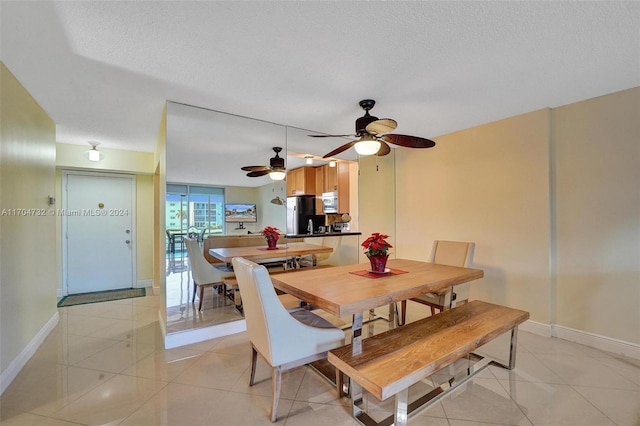 dining room with ceiling fan, light tile patterned flooring, and a textured ceiling