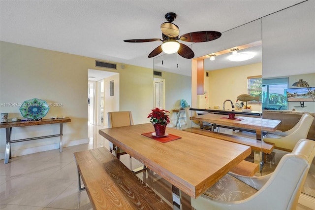 dining room featuring ceiling fan, light tile patterned flooring, and a textured ceiling