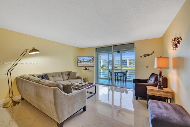 living room with floor to ceiling windows, light tile patterned floors, and a textured ceiling