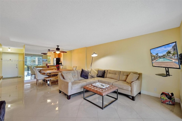 tiled living room with a textured ceiling and ceiling fan