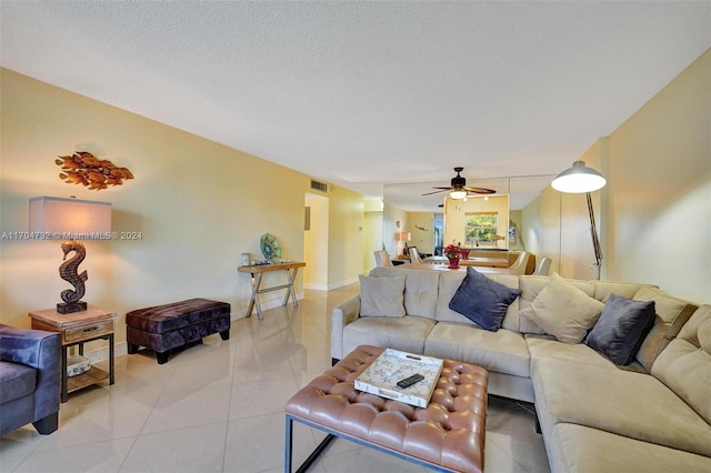 tiled living room featuring ceiling fan and a textured ceiling