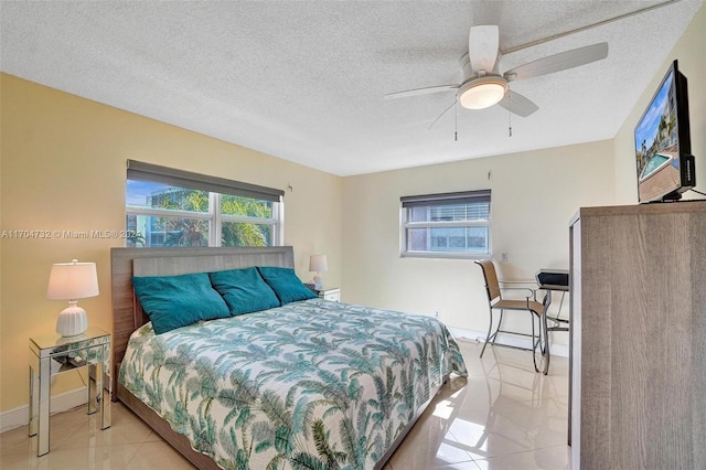 bedroom featuring multiple windows, ceiling fan, and a textured ceiling