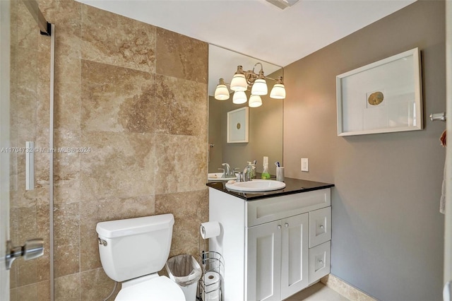 bathroom featuring vanity, tile walls, and toilet