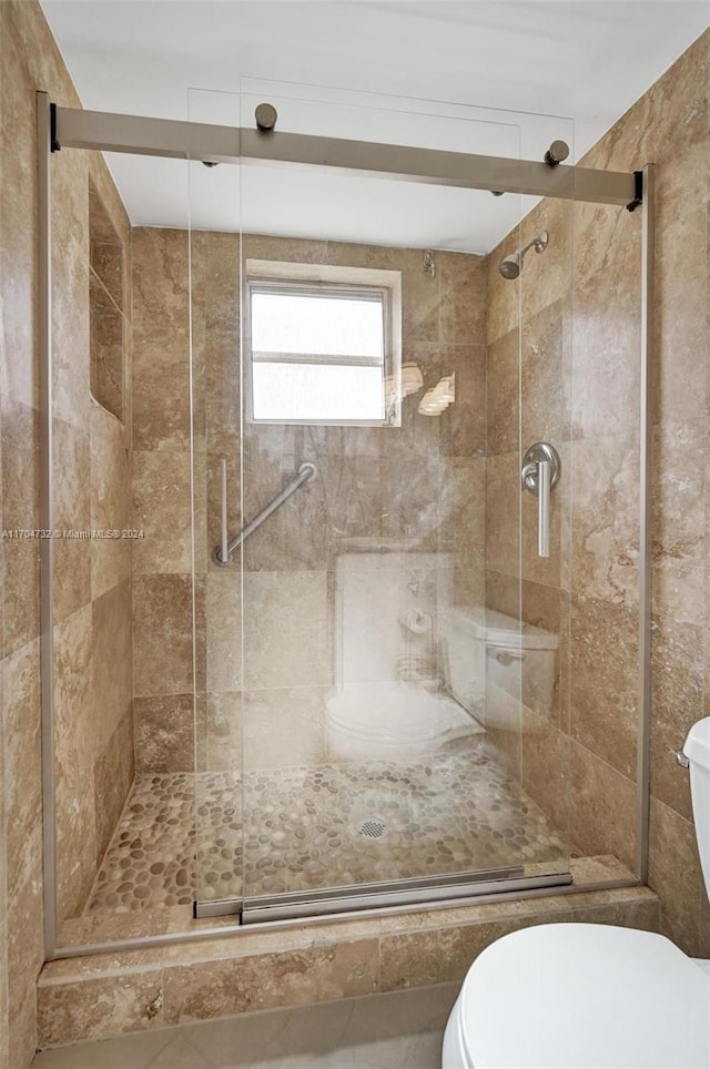 bathroom with toilet and an enclosed shower