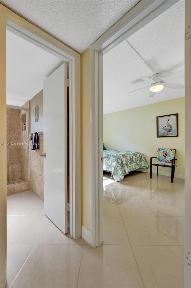 tiled bedroom featuring a textured ceiling and ceiling fan