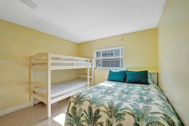 bedroom with light tile patterned floors and a textured ceiling