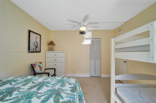 bedroom with ceiling fan, light tile patterned floors, and a closet