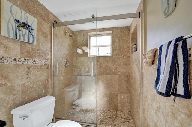 bathroom with toilet and tiled shower