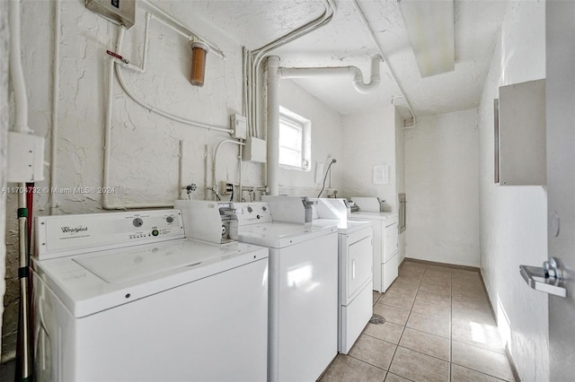 clothes washing area featuring separate washer and dryer and light tile patterned floors