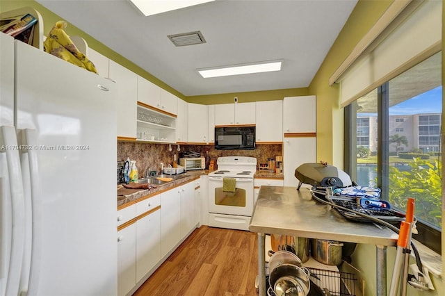 kitchen with light hardwood / wood-style floors, white cabinetry, and white appliances