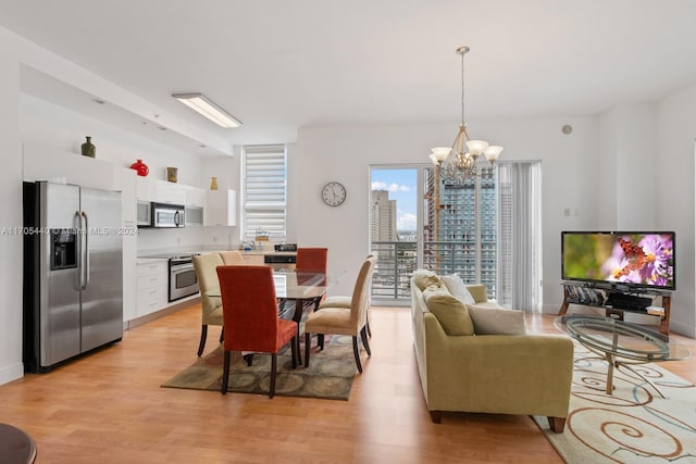 dining space with a chandelier and light hardwood / wood-style floors