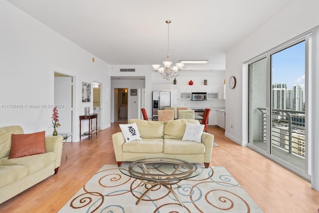 living room featuring a notable chandelier and light wood-type flooring