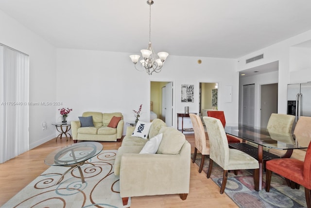 living room with light hardwood / wood-style flooring and a chandelier