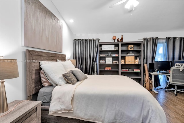 bedroom featuring ceiling fan, dark wood-type flooring, and lofted ceiling