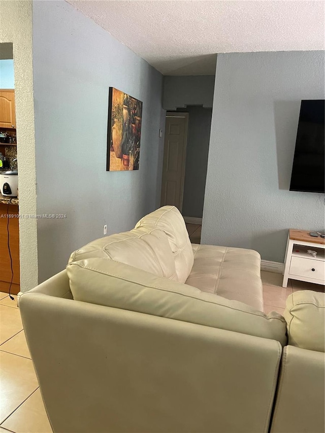 living room with light tile patterned flooring and a textured ceiling