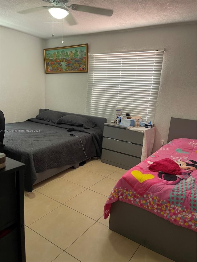 tiled bedroom featuring ceiling fan