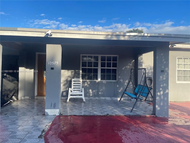 view of exterior entry featuring a patio area