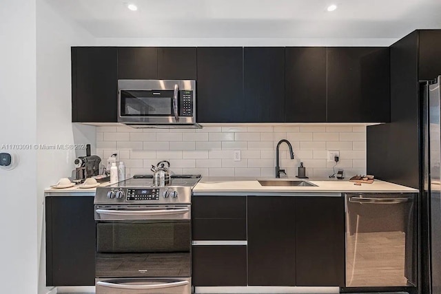 kitchen featuring decorative backsplash, appliances with stainless steel finishes, and sink