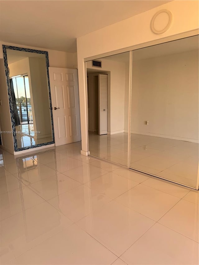 unfurnished bedroom featuring tile patterned flooring and a closet