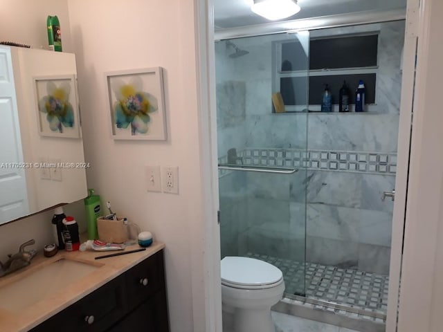 bathroom featuring vanity, toilet, and an enclosed shower