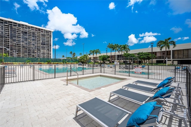 view of swimming pool featuring a jacuzzi and a patio