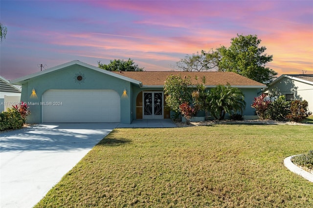 single story home with french doors, a yard, and a garage