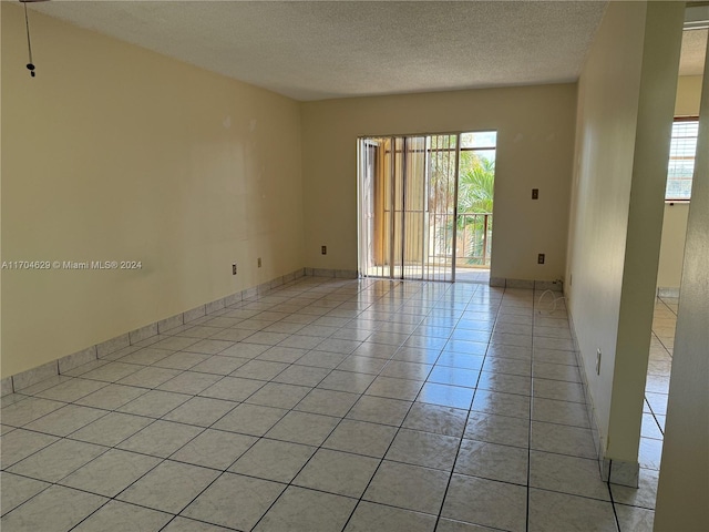 tiled spare room with a healthy amount of sunlight and a textured ceiling