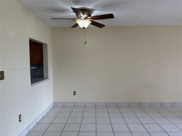 tiled spare room with ceiling fan and a textured ceiling