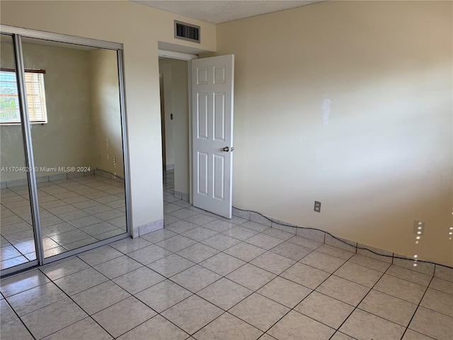 unfurnished bedroom featuring a closet and light tile patterned floors