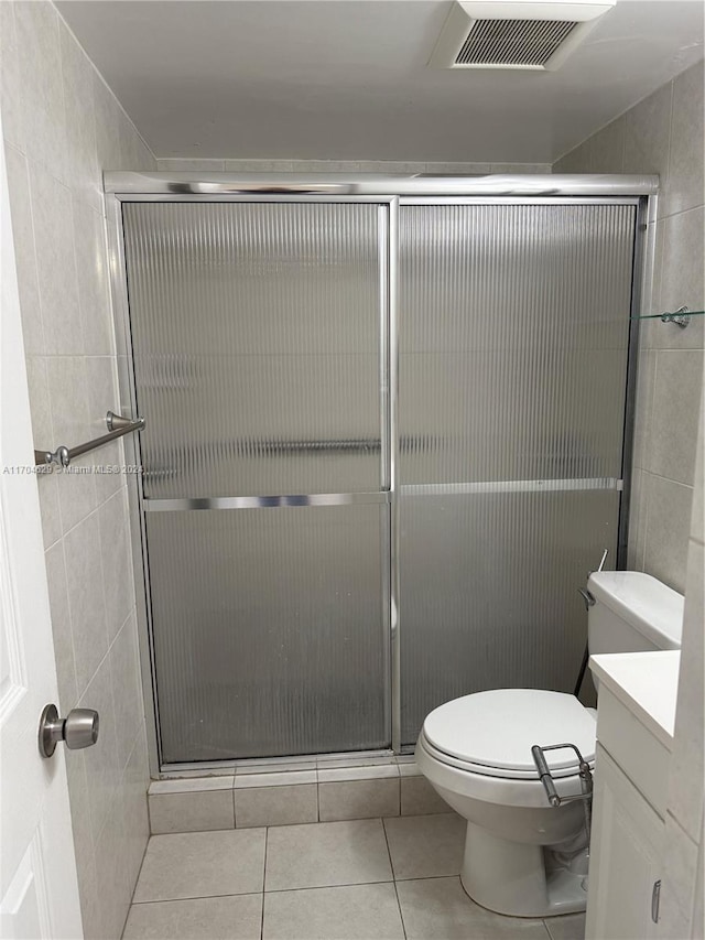 bathroom featuring tile patterned floors, vanity, toilet, and walk in shower