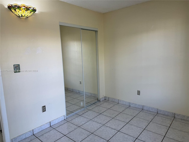 unfurnished bedroom featuring a closet and light tile patterned floors