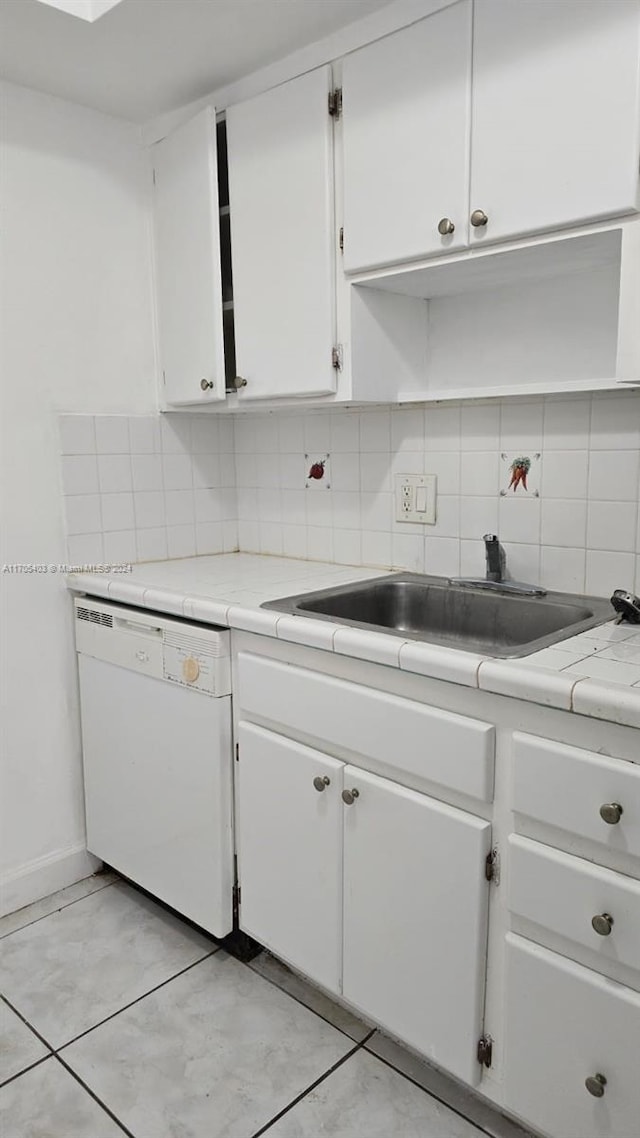 kitchen featuring white cabinets, white dishwasher, tasteful backsplash, and sink