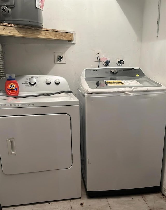 washroom with light tile patterned floors and washer and dryer