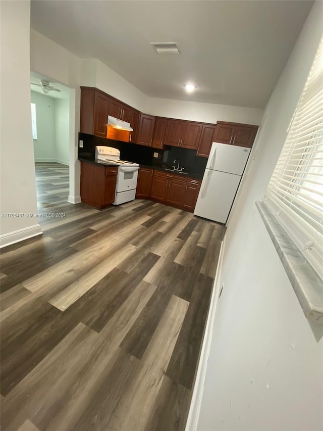 kitchen with white appliances, dark hardwood / wood-style floors, backsplash, and sink