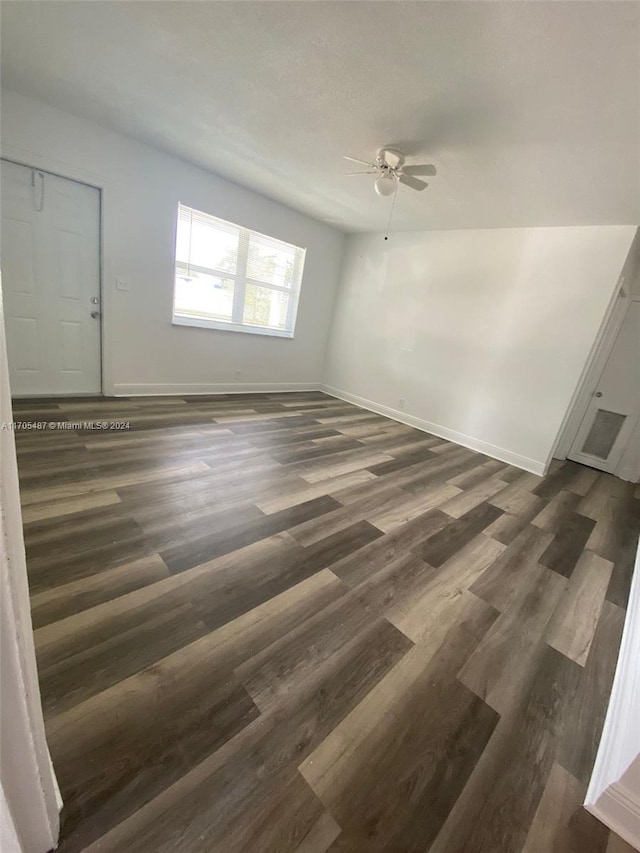 unfurnished room with dark hardwood / wood-style floors and ceiling fan