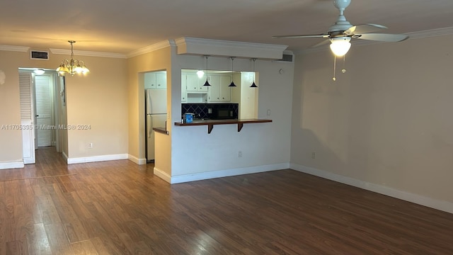 interior space with ceiling fan with notable chandelier, dark hardwood / wood-style floors, and ornamental molding