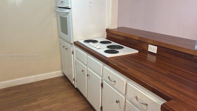 kitchen with white cabinets, white appliances, and dark hardwood / wood-style floors