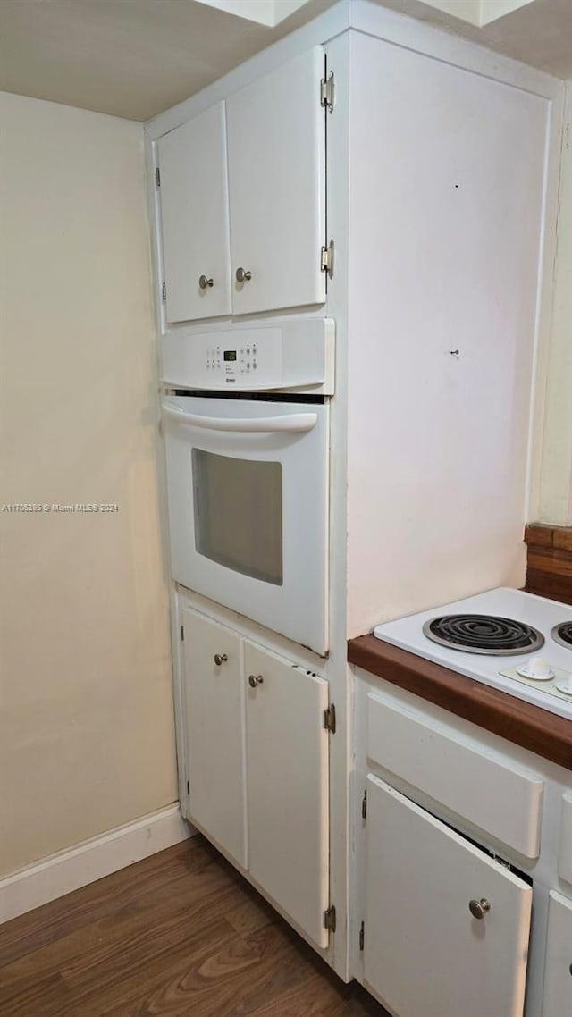 kitchen featuring white cabinetry, white appliances, and dark wood-type flooring