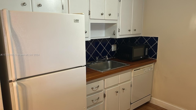 kitchen featuring white cabinets, white appliances, and backsplash