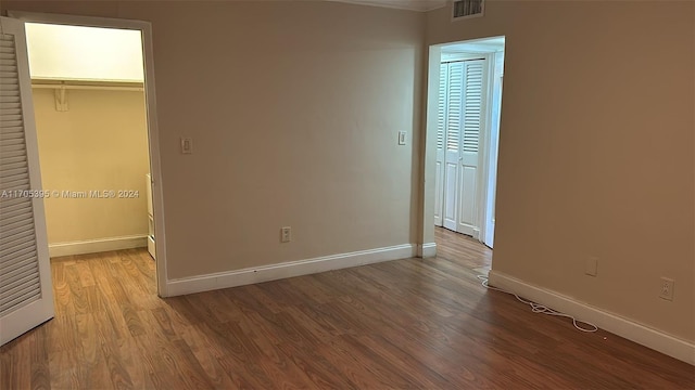 unfurnished bedroom with a closet, a walk in closet, and light hardwood / wood-style flooring