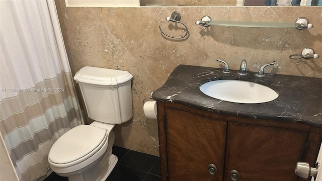 bathroom with tile patterned flooring, vanity, toilet, and tile walls