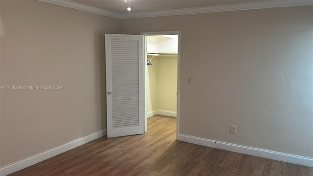 spare room featuring wood-type flooring and ornamental molding