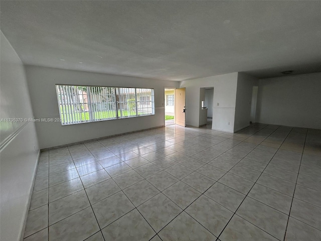 unfurnished room featuring light tile patterned floors and a textured ceiling